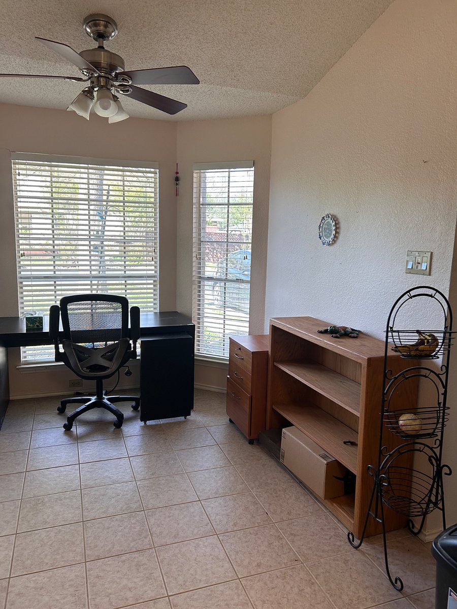 Parlor area next to kitchen with bay window and work desk