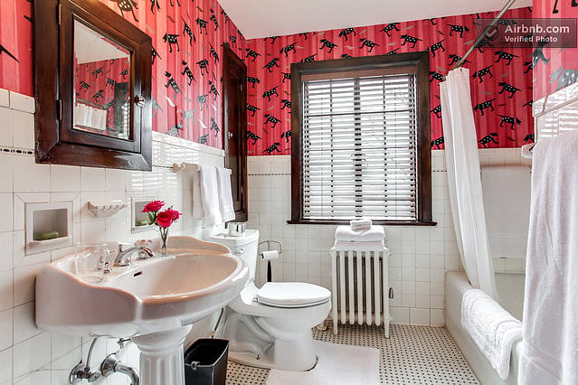 The second floor guest bathroom is the original bath to the house, and features handpainted wallpaper.