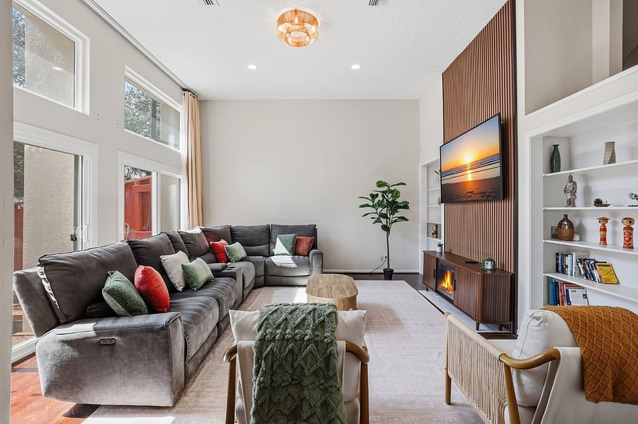 Living room with a large recliner couch for 7 people + 2 accent chairs. 75 smart TV and board games for your couch potato days.