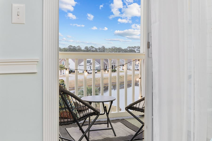 Relaxing balcony with view of pond and pool view on side.