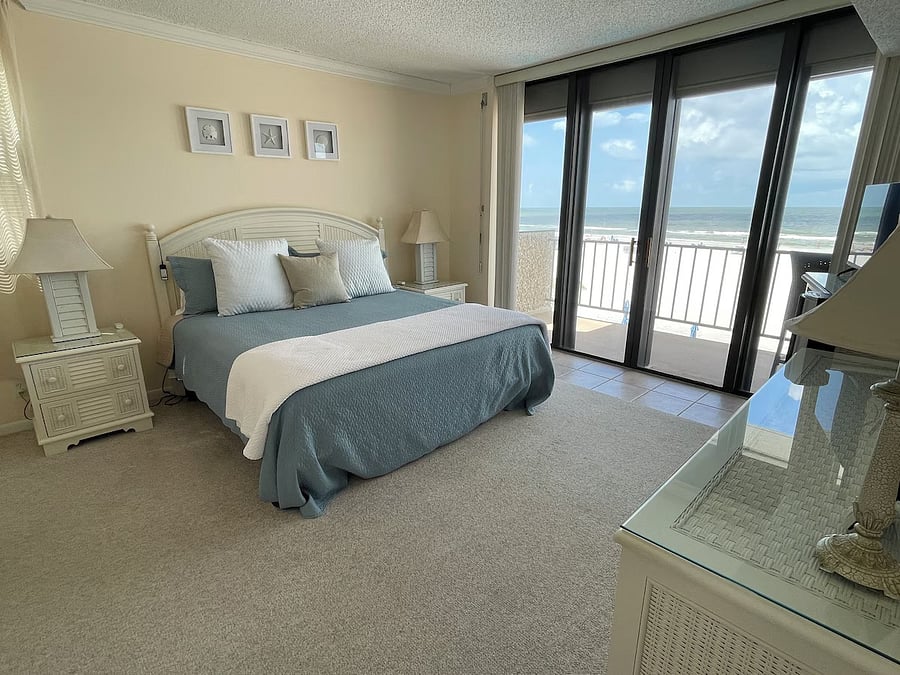 Master bedroom with floor to ceiling sliding glass doors that open to ocean-front