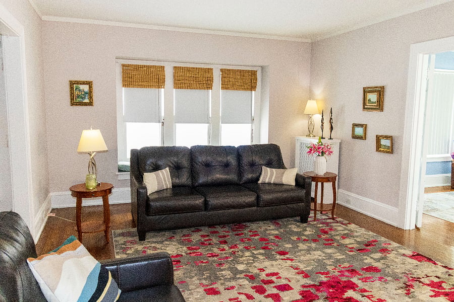 Step into a grand, sun-filled living room in this 1920s central hall colonial. With high ceilings, original hardwood floors, and a flowing layout, the room offers ample space for both formal gatherings and relaxed family evenings. Large windows bathe the space in natural light, highlighting the homes timeless charm.