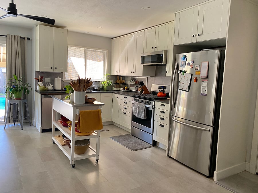 Open kitchen with island, with sliding door to the left that leads to the back yard and pool