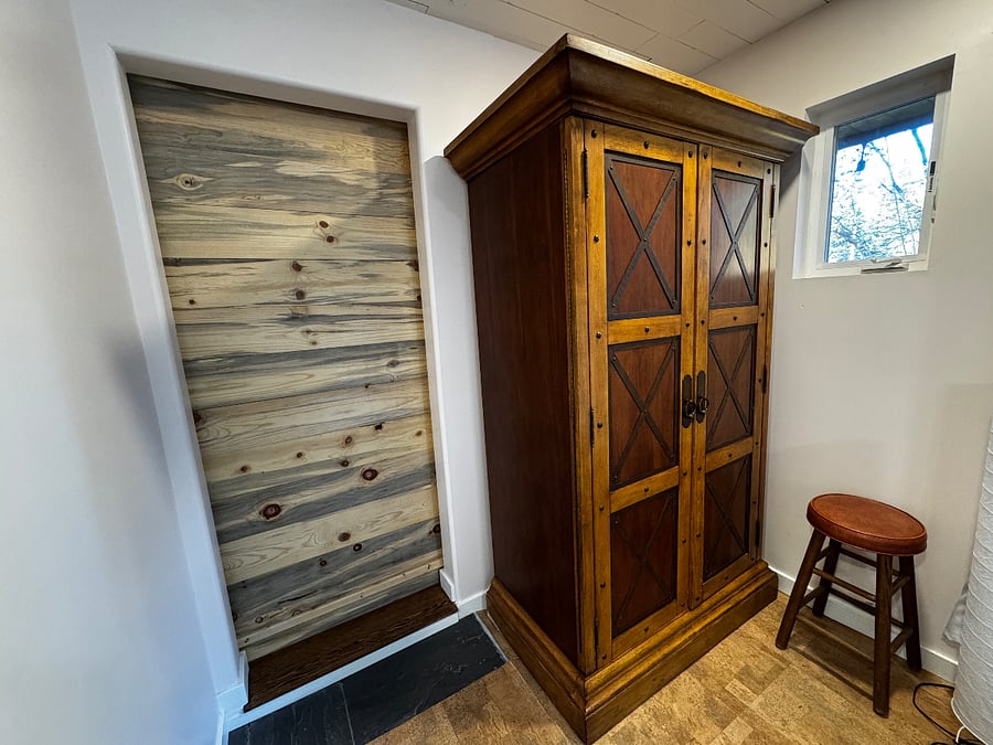 This doorway with the custom sliding barn door opens to the dining room. This armoire stores bed and bathroom linens and more.
