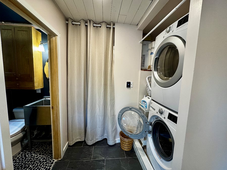 The laundry area is adjacent to the workspace with the large window to the backyard. The washer and dryer are excellent. These spaces boast heated floors and the bathroom offers a utility sink and a smart heated bidet toilet seat.