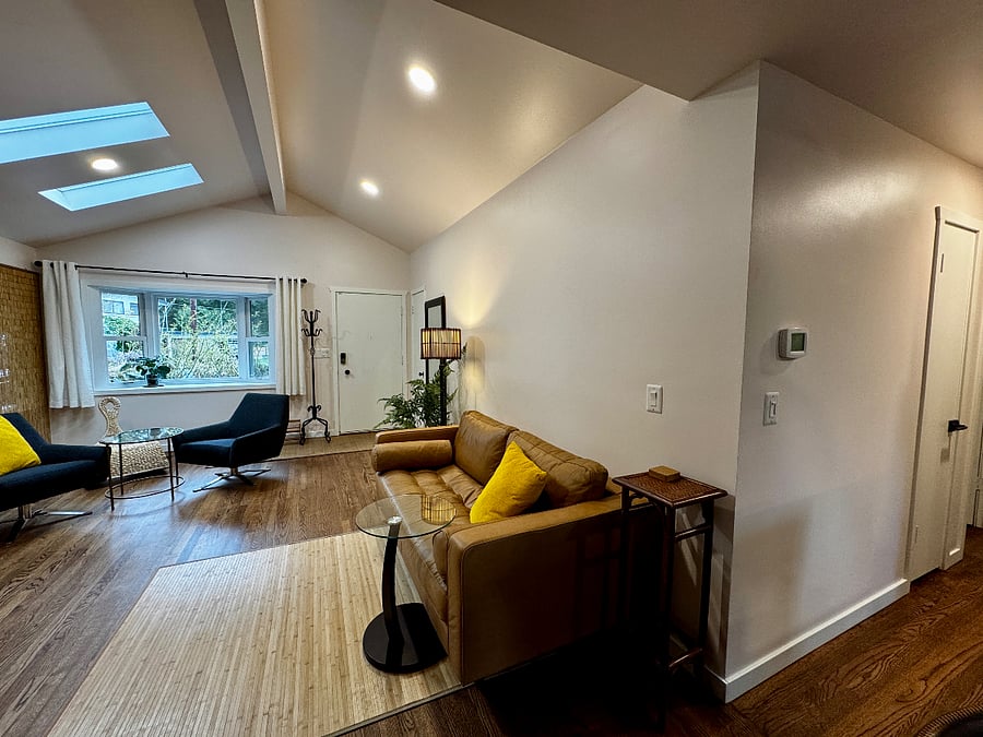 On the right, between the living room and the kitchen is the hallway that leads to the two bedrooms, office, and full bathroom. On the wall in  this picture is the control for the heat pump's heating/AC.