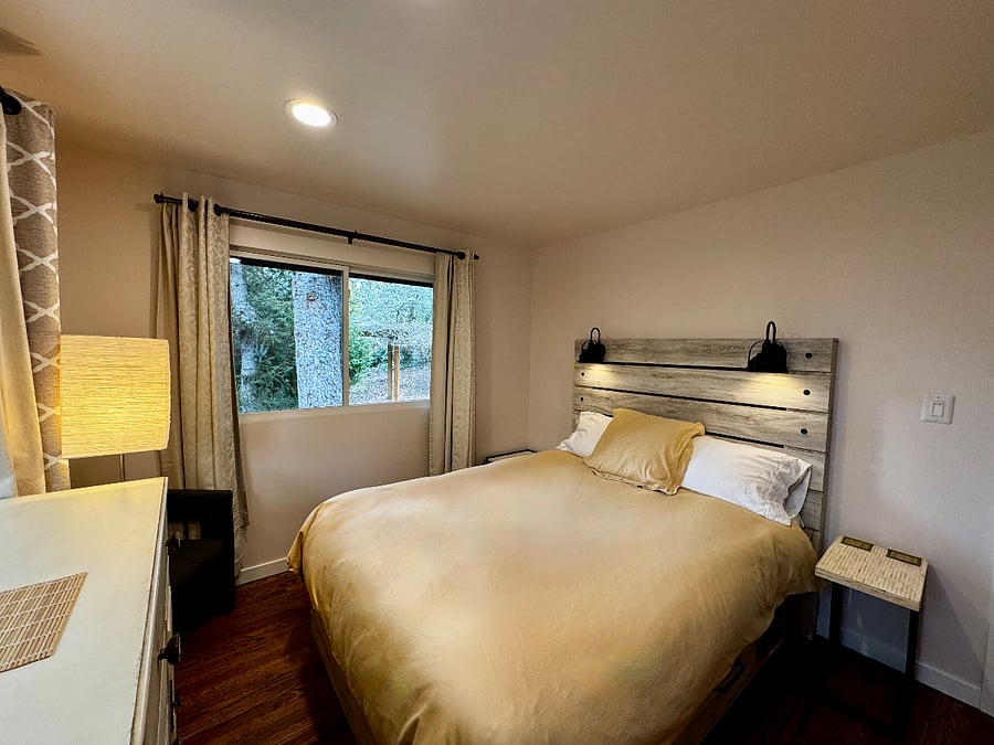 This bedroom facing the backyard has a solid wood dresser, an armoire feating rattan faces, and a meditation nook (or closet, as you wish!).