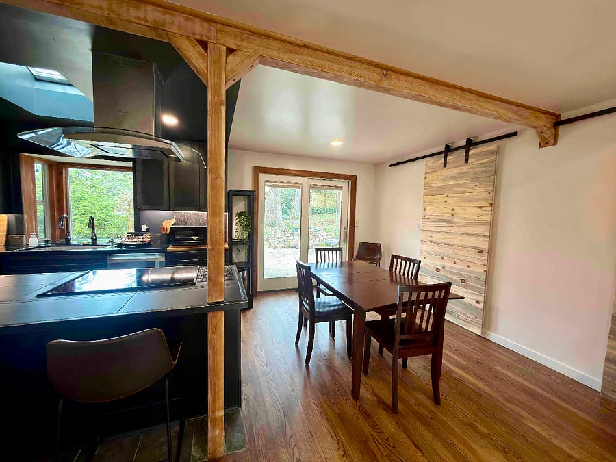 A smaller barn door encloses a pantry stocked with additional kitchen appliances (such as a blender, food processor, etc).