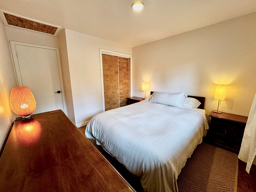 This bedroom has a closet with sliding doors.
