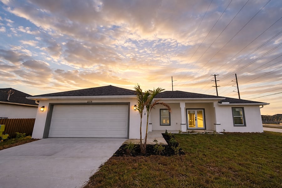 Clean modern curb appeal with crisp white stucco, dark trim accents, and a young palm tree welcoming you home. Plenty of parking right at your door.