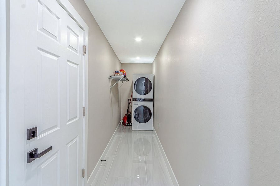 Dedicated laundry hallway with a full-size stacked washer and dryer everything you need for extended stays, right inside the home.