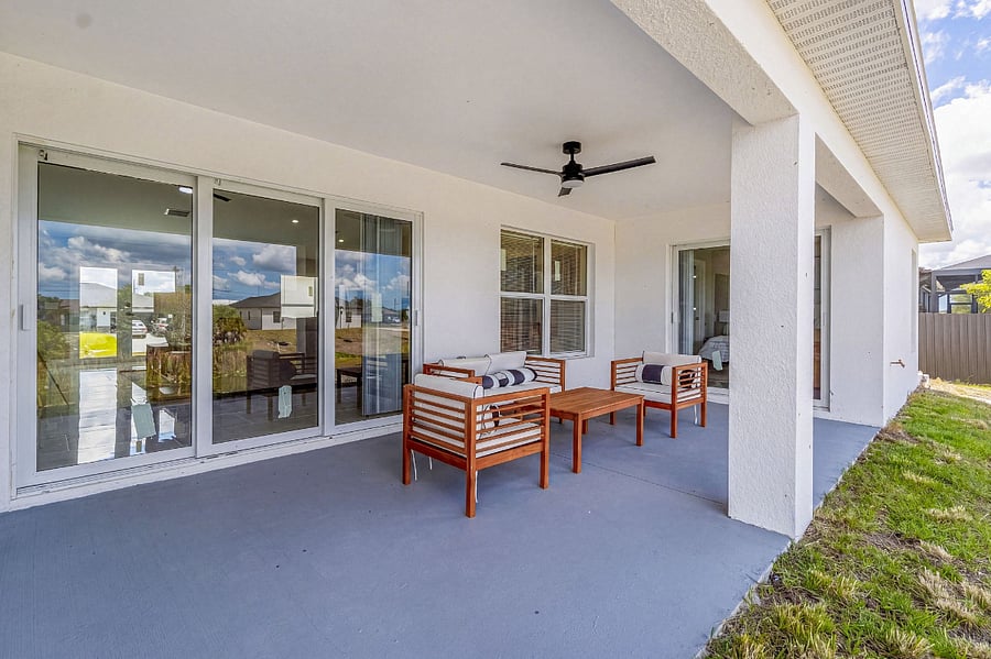 Covered back patio with teak outdoor furniture, ceiling fan, and a direct view of the peaceful canal your own private outdoor lounge for morning coffee or evening unwinding.