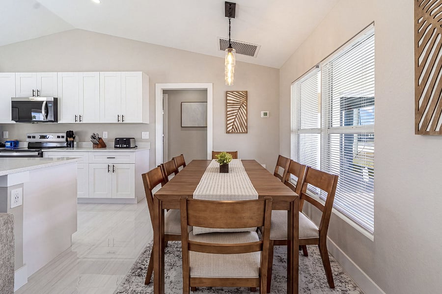 Dining room and kitchen flow together beautifully under soaring vaulted ceilings. The 8-seat table is perfect for group dinners, set alongside the open kitchen for effortless entertaining.