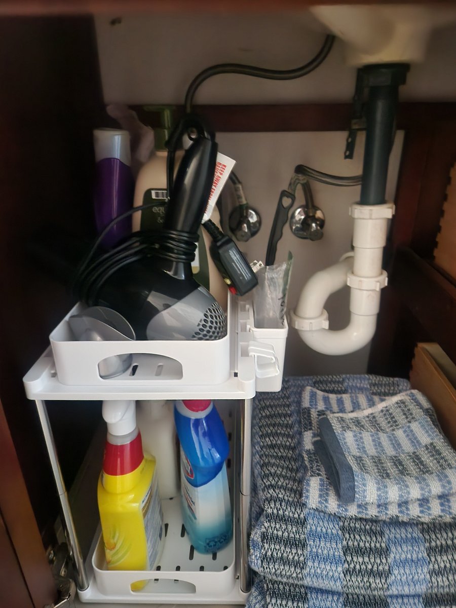 Under bathroom sink. Blow-dryer cleaning supplies, extra towels