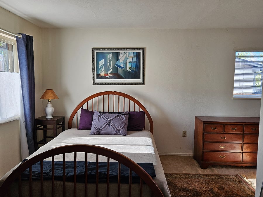 Queen bed in primary bedroom. (even though this pic makes the bed look narrower, this is a Queen.)