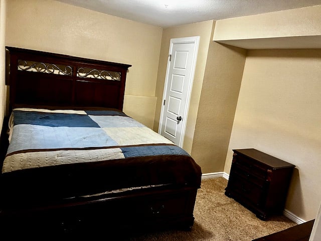 Bedroom with under bed drawers, 2 small dressers, and closet.