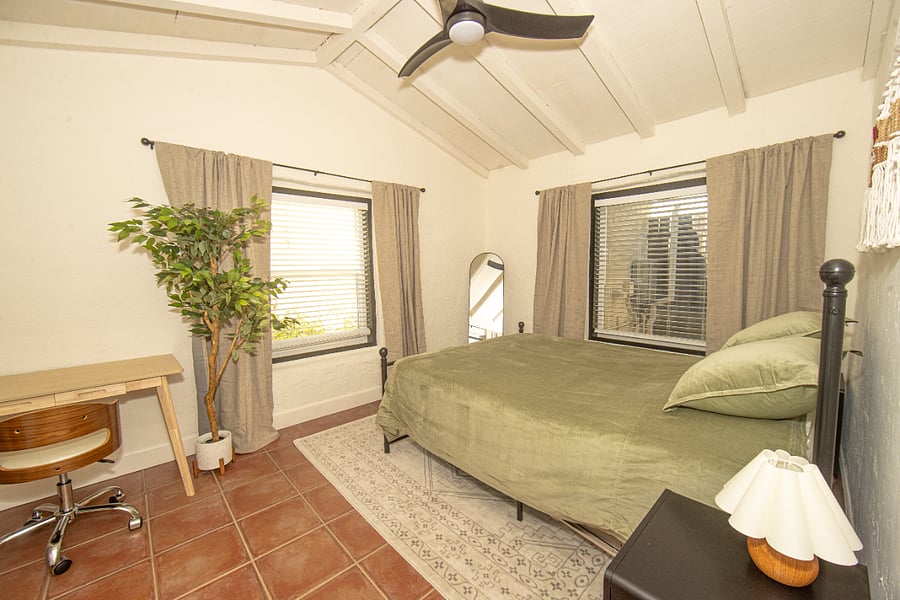 primary bedroom with queen bed and blackout curtains