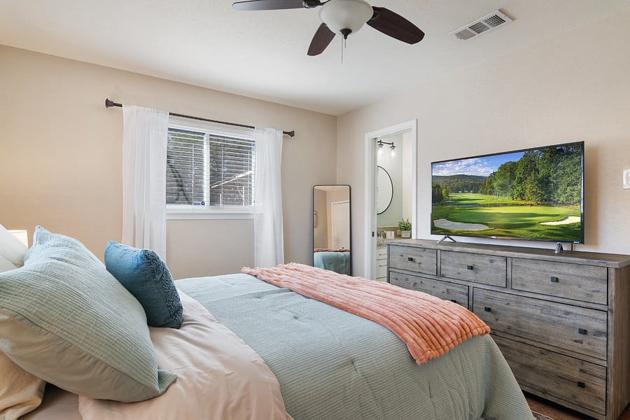 Primary bedroom with queen bed, smart TV, two closets, and en-suite bathroom