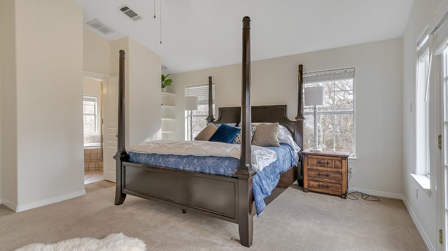 Master bedroom with king size bed. French door to a deck with a look at Lake Austin.