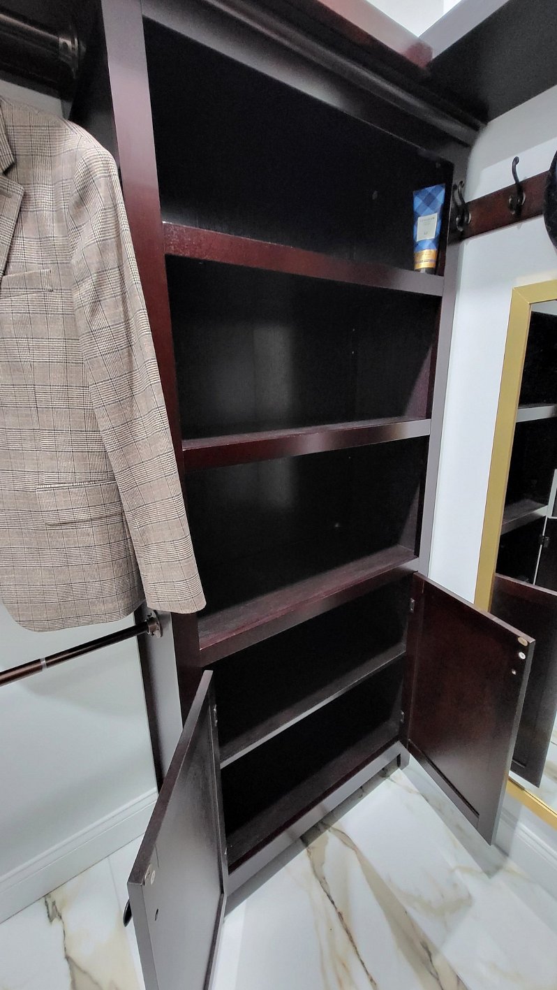 Primary Bedroom Walk-In Closet with Shelves and cabinet storage.