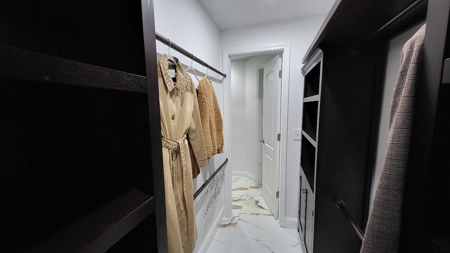 Primary Bedroom Walk-In Closet with Shelves and cabinet storage.