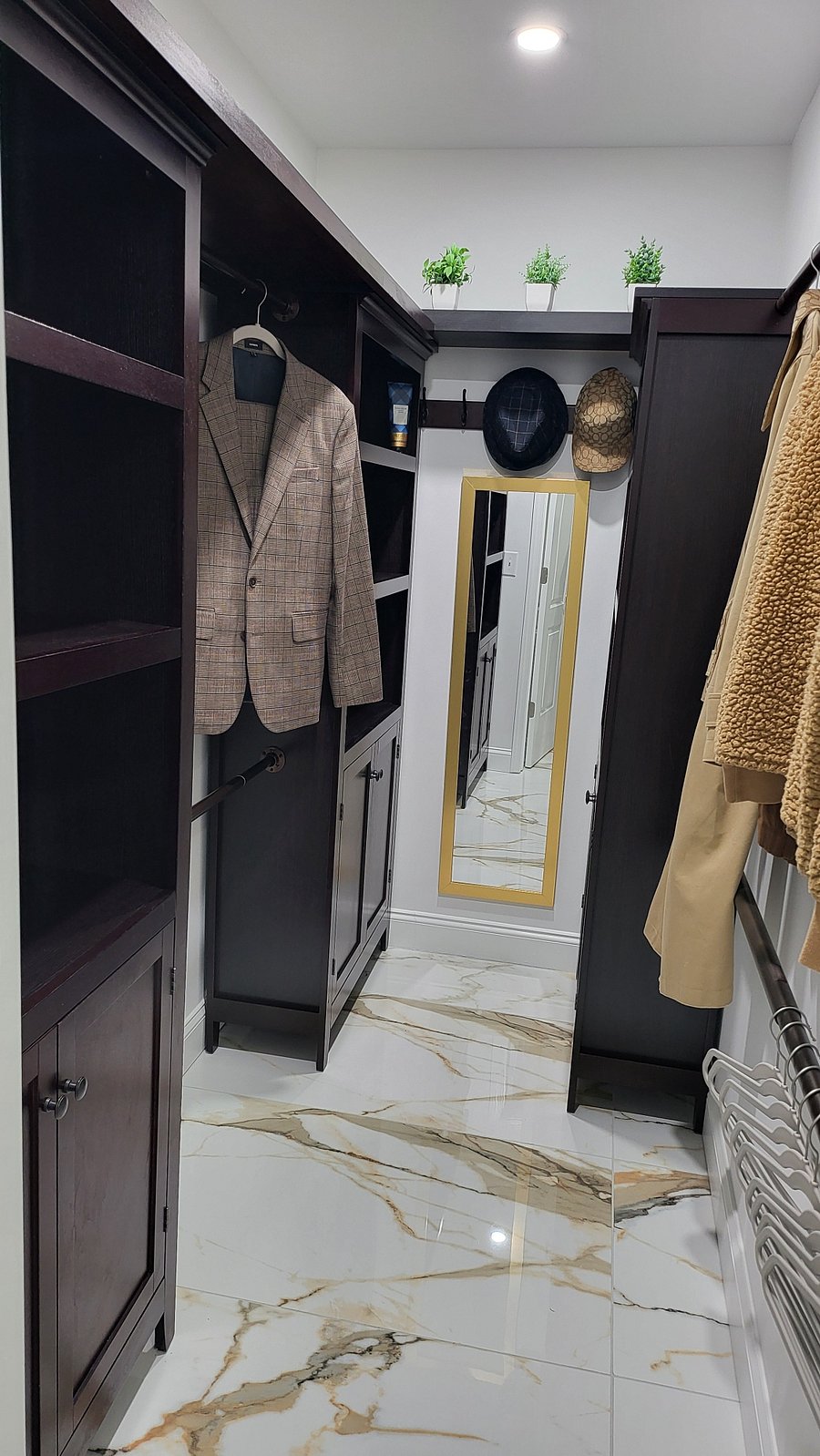 Primary Bedroom Walk-In Closet with Shelves and cabinet storage.