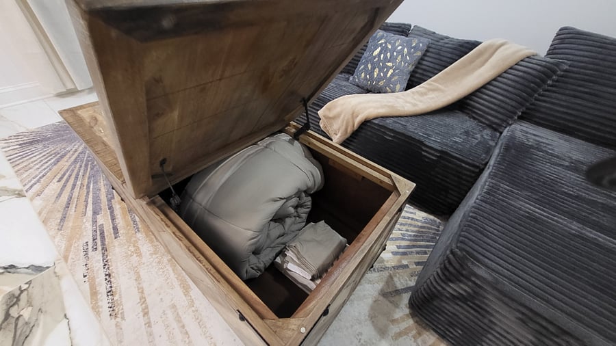 Chest stores queen air mattress and bedding set.