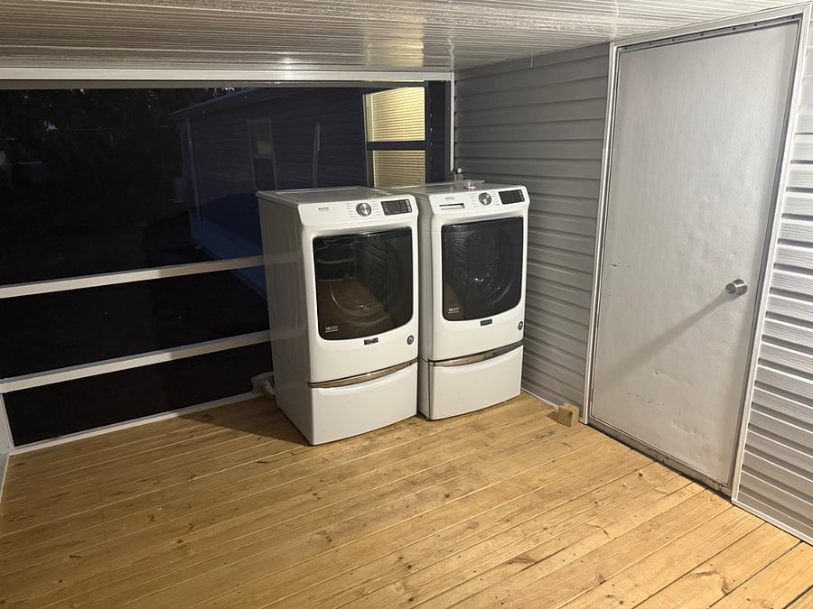 Washer and dryer located on screened in porch on back side of house facing the lake. 