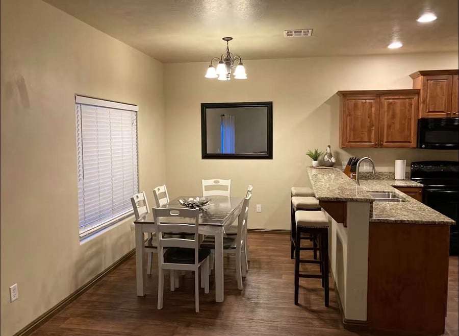 Open dining area beside a fully equipped kitchen