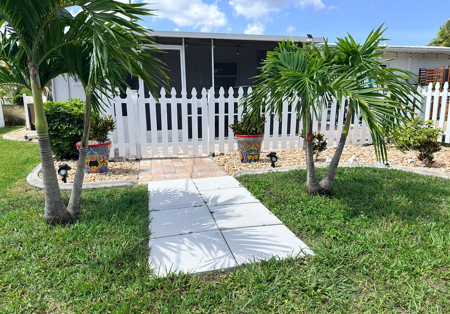 Backyard fence entrance with screened patio in the back 