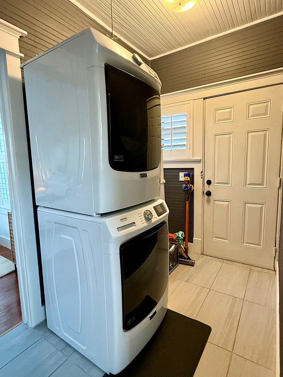 Laundry area, including full-size GE washer/dryer, Dyson vacuum, cleaning supply storage