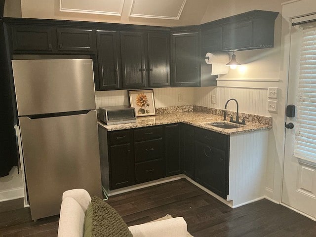 Kitchen area with a full size refrigerator and freezer, ninja oven, coffee maker, ample dishes and kitchen wares supplied