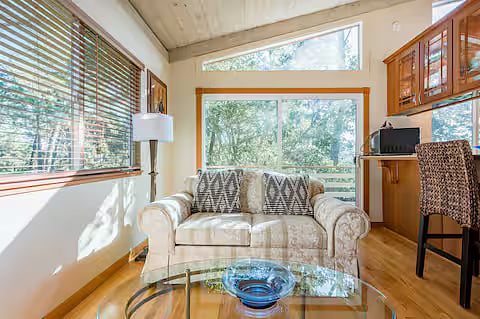 Den. Comfortable loveseat and fireplace with candles.