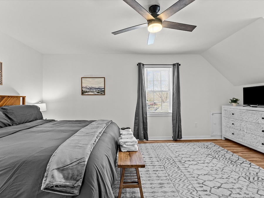 Bedroom 3 - Upstairs Bedroom:
This bedroom can be found upstairs and offers a king size luxury pillow top mattress, large walk-in closet, smart tv, blackout curtains, ceiling fan. This bedroom has direct access to the upstairs shared ensuite equipped with vanity, toilet and tub / shower combo. This bedroom is also equipped with an office desk & adjustable desk chair. 32" UHD SmartTV (requires guest login to their favorite streaming service).