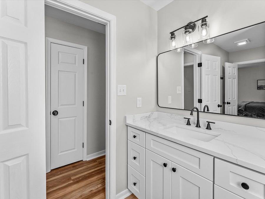 The upstairs full ensuite boasts a large shared ensuite with a 48" vanity with quartz top, toilet, and shower tub combo.
