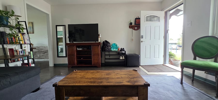 Living room view from couch with front door open. Guests enjoy Pecan Porch Retreat Austin TX