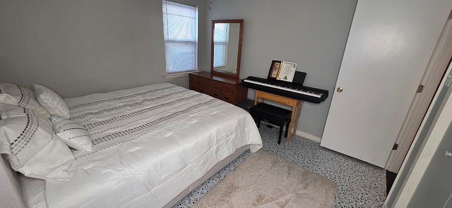 King bed, piano, dresser, mirror and desk at Pecan Porch Retreat