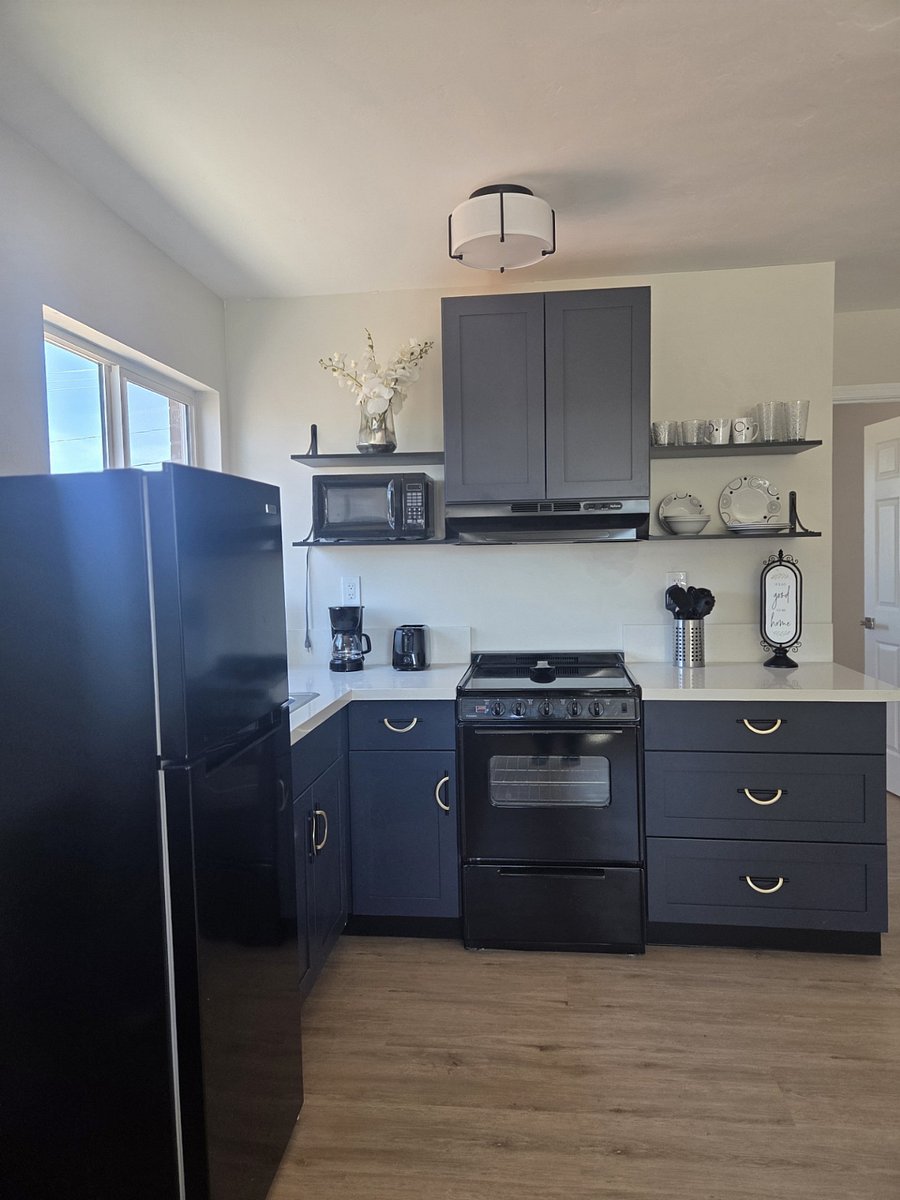 Kitchen area has good size refrigerator, microwave and stove with oven