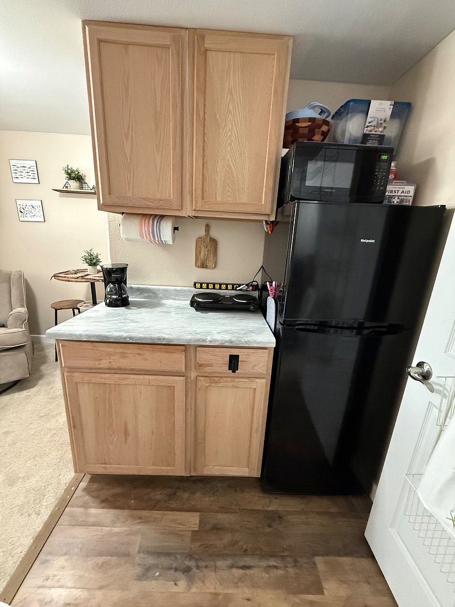 Full size refrigerator and freezer, microwave, 2-burner induction plate, coffee maker, dishes, silverware, cooking utensils and 5 gallon water tank