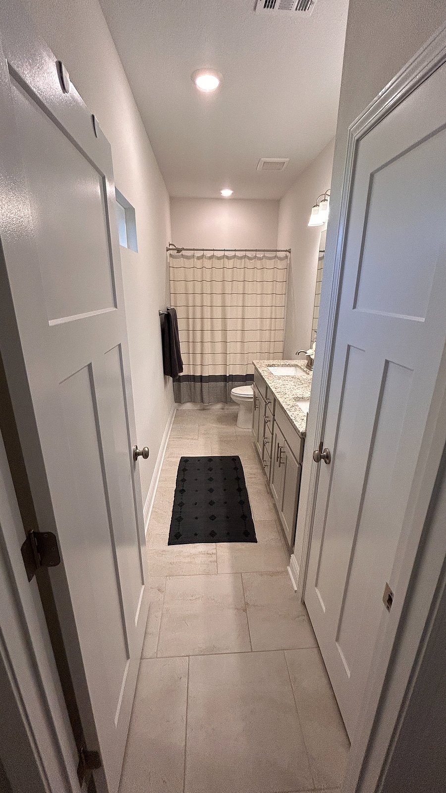 Primary bathroom with double sinks, and shower tub combination