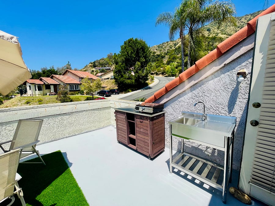 Stainless steel top cooking cart equipped with 17 propane griddle, accompanied by stainless steel sink. Perfect for outdoor cooking and dining.