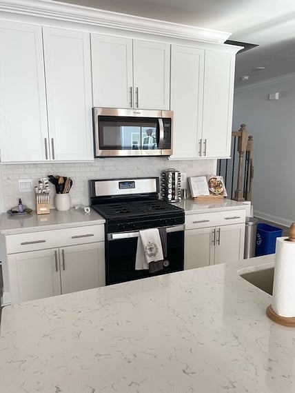 Eight, extra tall, white cabinets w/stainless steel hardware for plenty of storage. All Whirlpool stainless steal appliances, gooseneck faucet, & large sink.