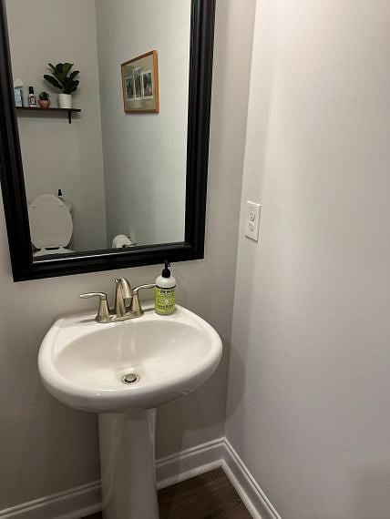 Half bath off foyer w/ pedestal sink.