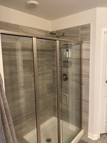 Large primary shower w/tile seat bench & inset tile shelves. Door to right is large walk-in closet. Linen closet beside shower w/extra towels/bedding.
