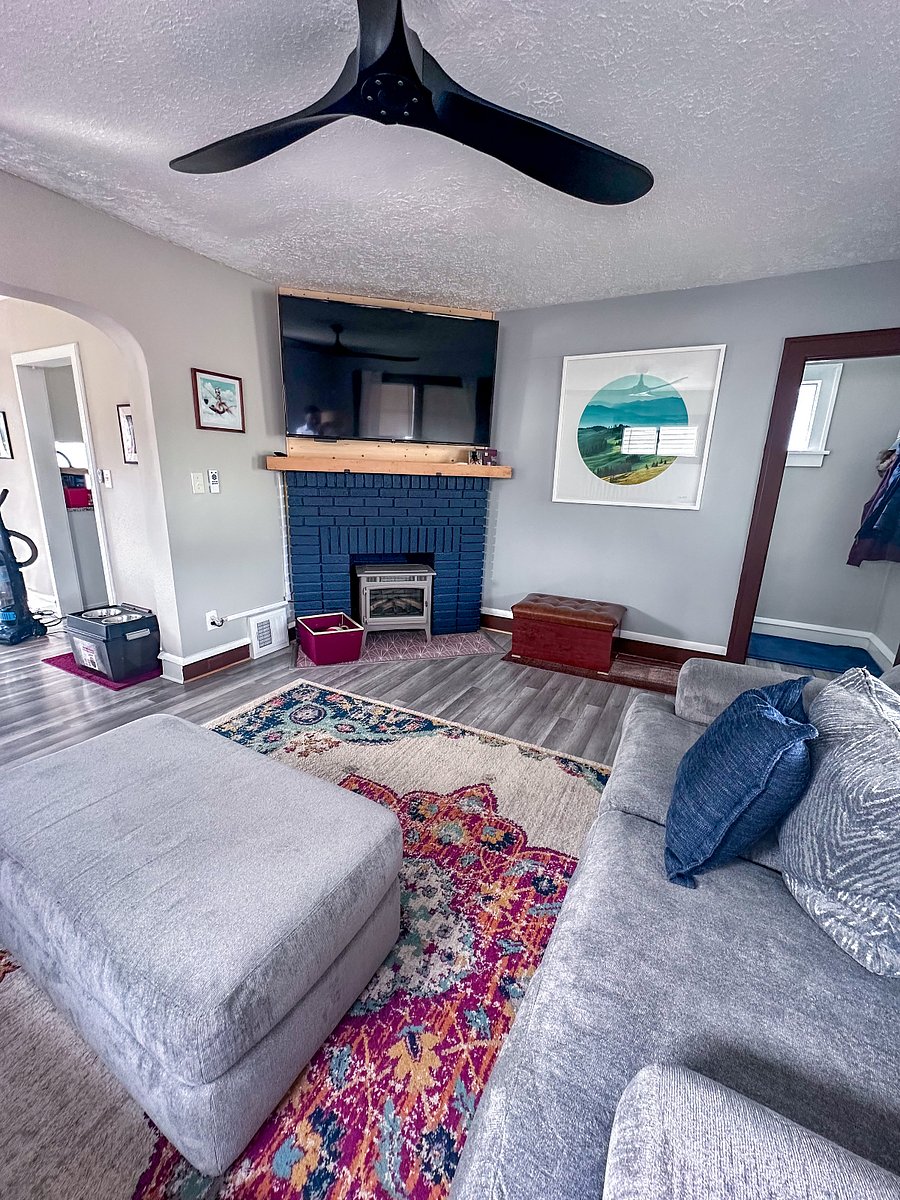 Shared living room, fireplace, and mounted TV, with staircase to the upstairs on the right.