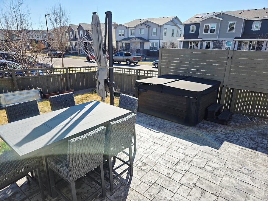 Outdoor dining area with large umbrella and hot tub