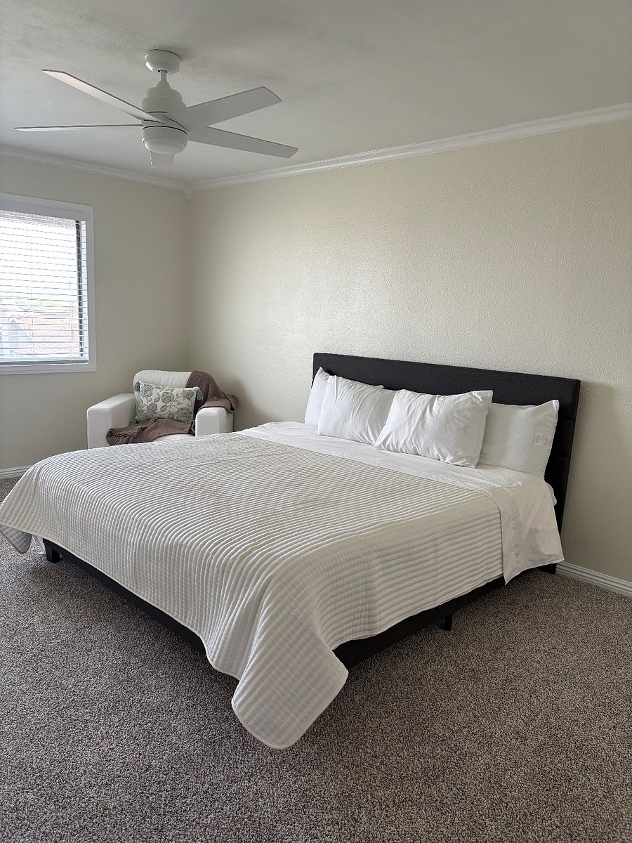 Master bedroom showing a comfortable king size bed and a sitting/reading space looking out towards the outside area.
