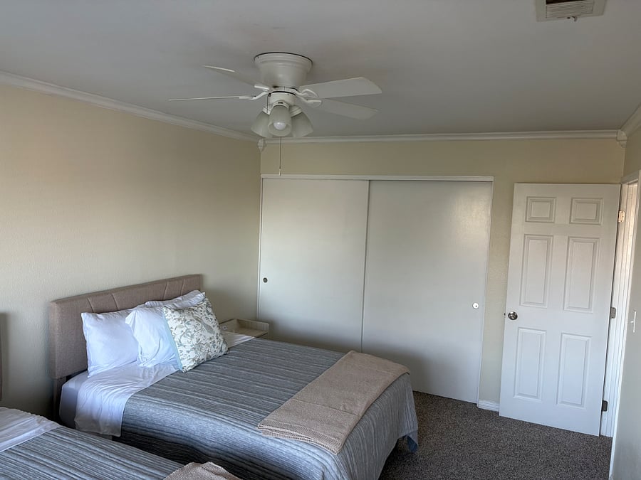 Second bedroom, full size beds each with a nightstand containing charging components