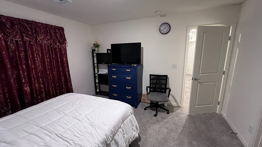 Master bedroom with office desk, cabinet, book shelf, and TV.