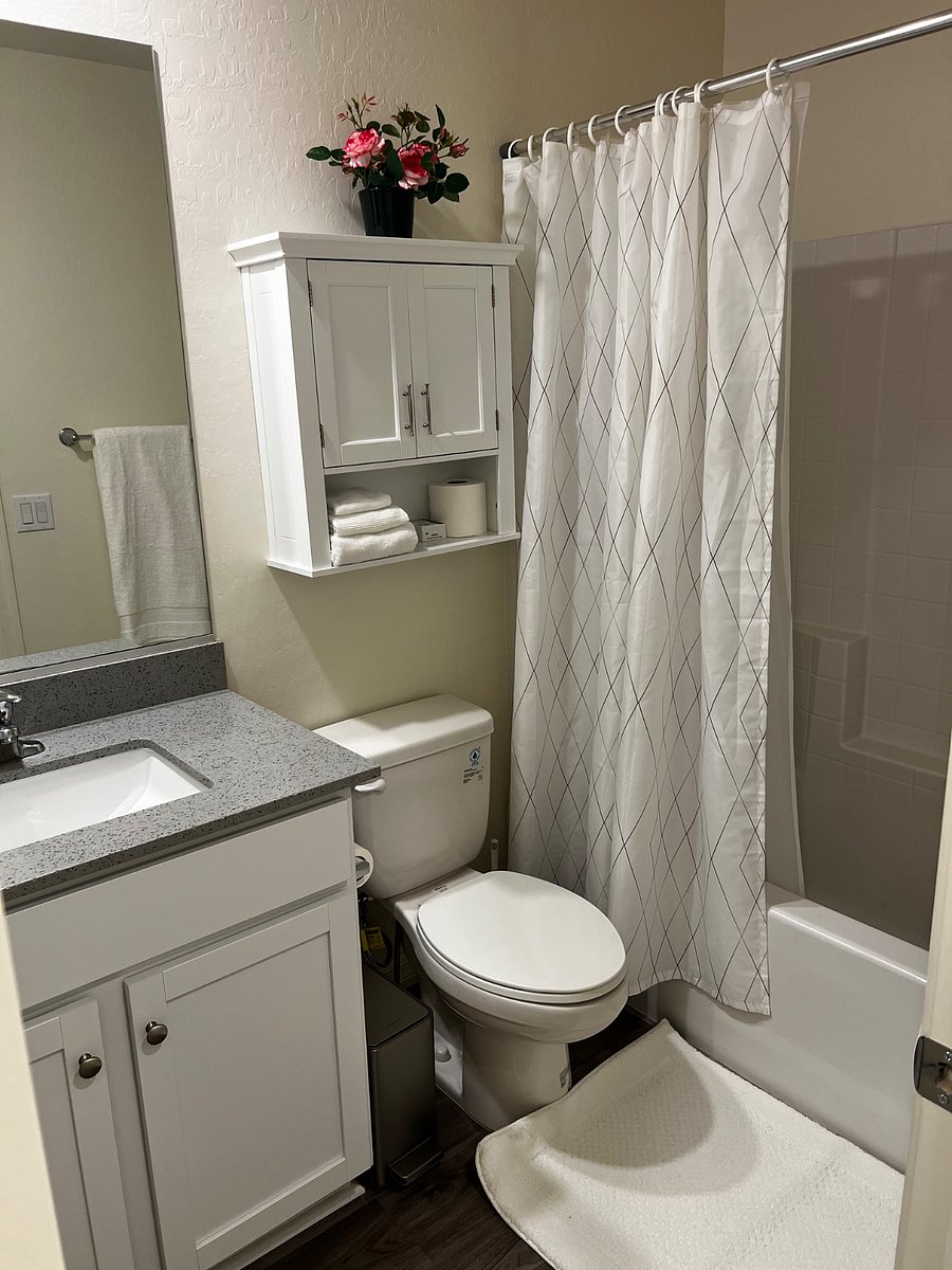 Full Bathroom 1 - Toilet Bowl with Bidet/Water Sprayer, Cabinets with towels, and sink.